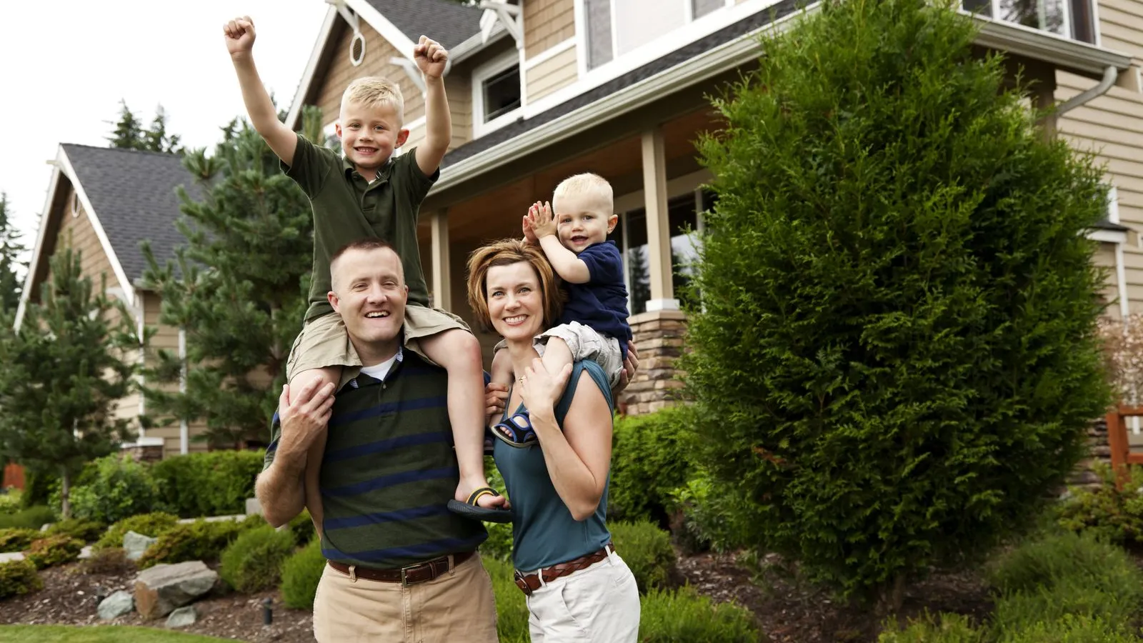 a group of people posing for a photo in front of a house