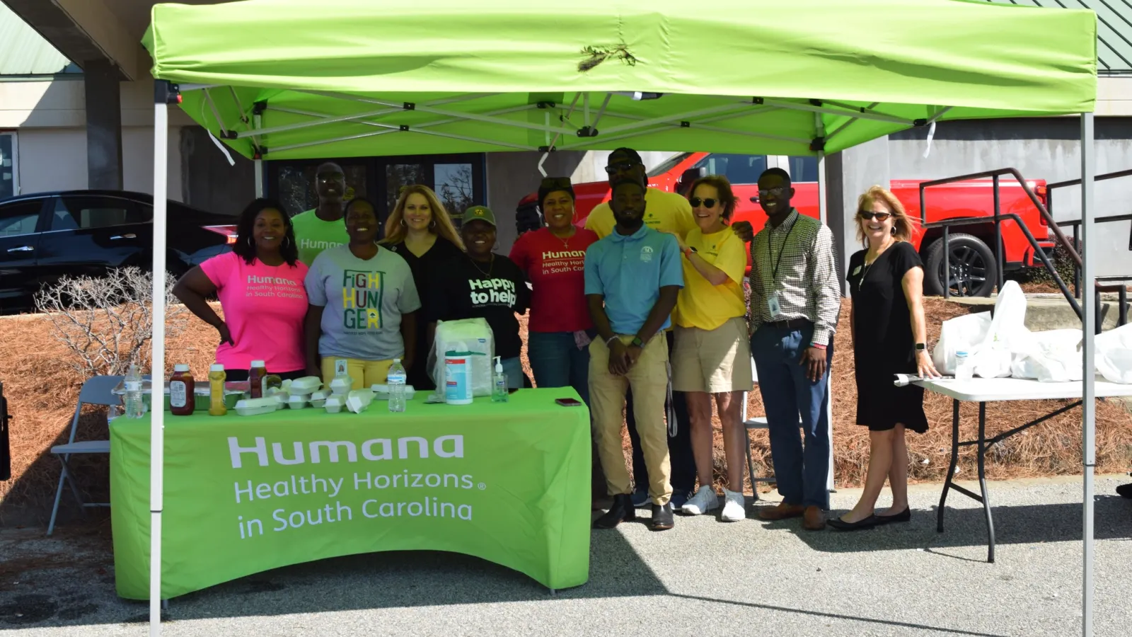 Group of people standing under a green Humana Healthy Horizons tent at an outdoor event in South Carolina