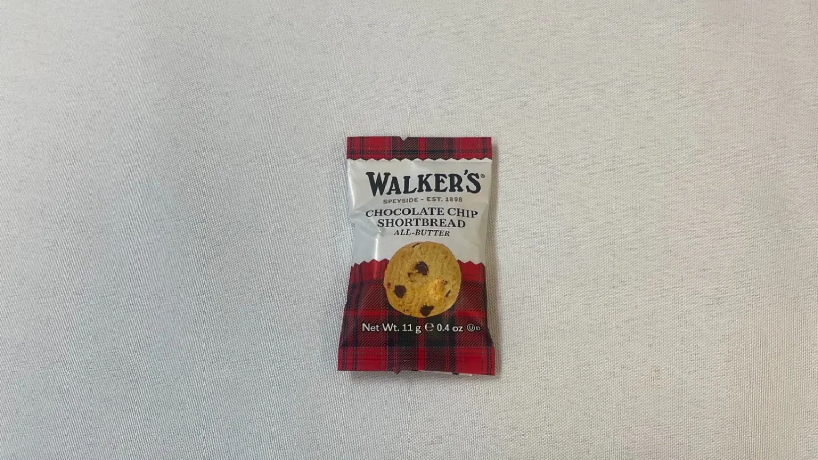 Walker's chocolate chip shortbread cookie pack next to quote about the art of doing nothing on white fabric.