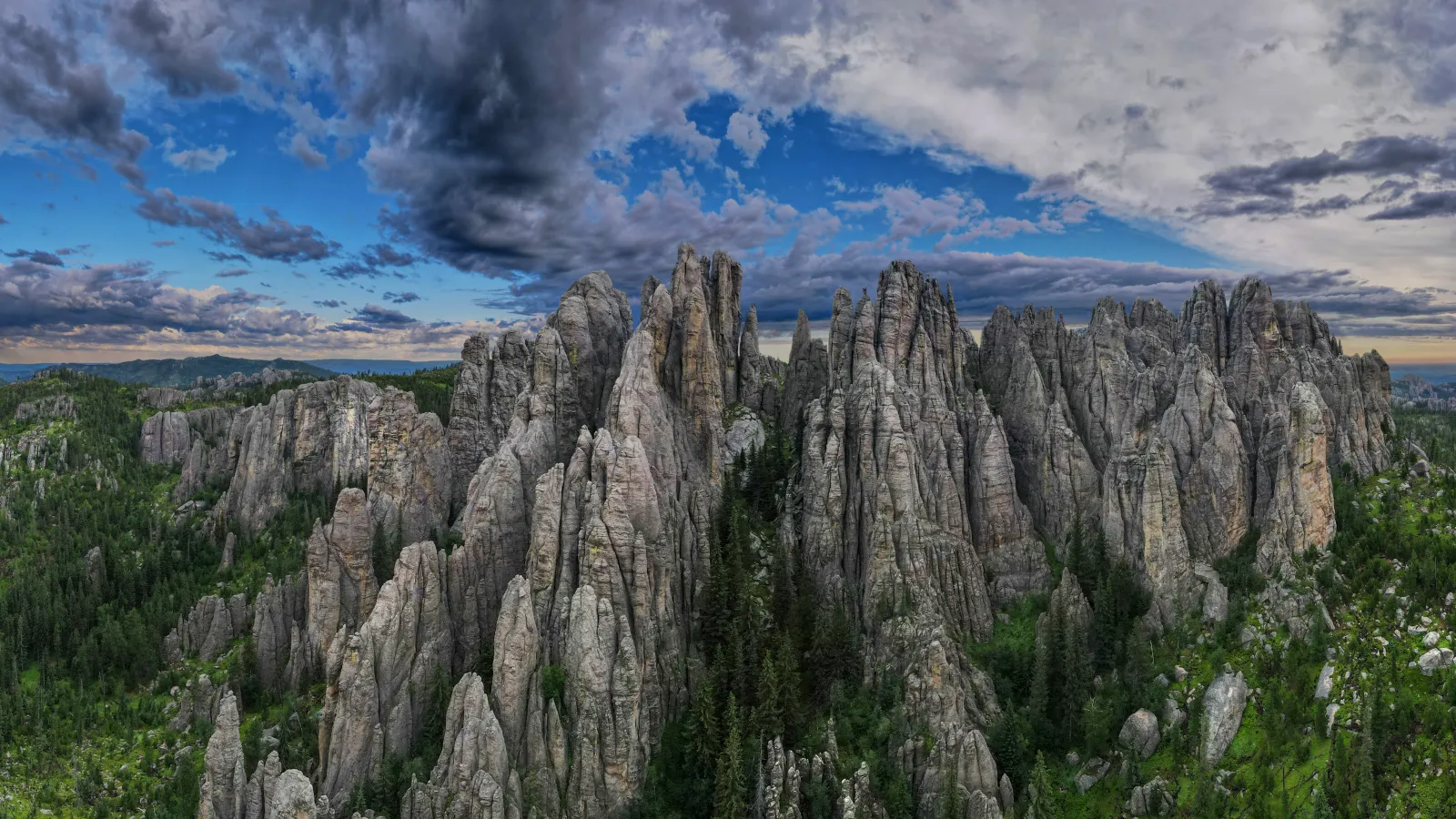 a rocky cliff with trees and clouds in South Dakota