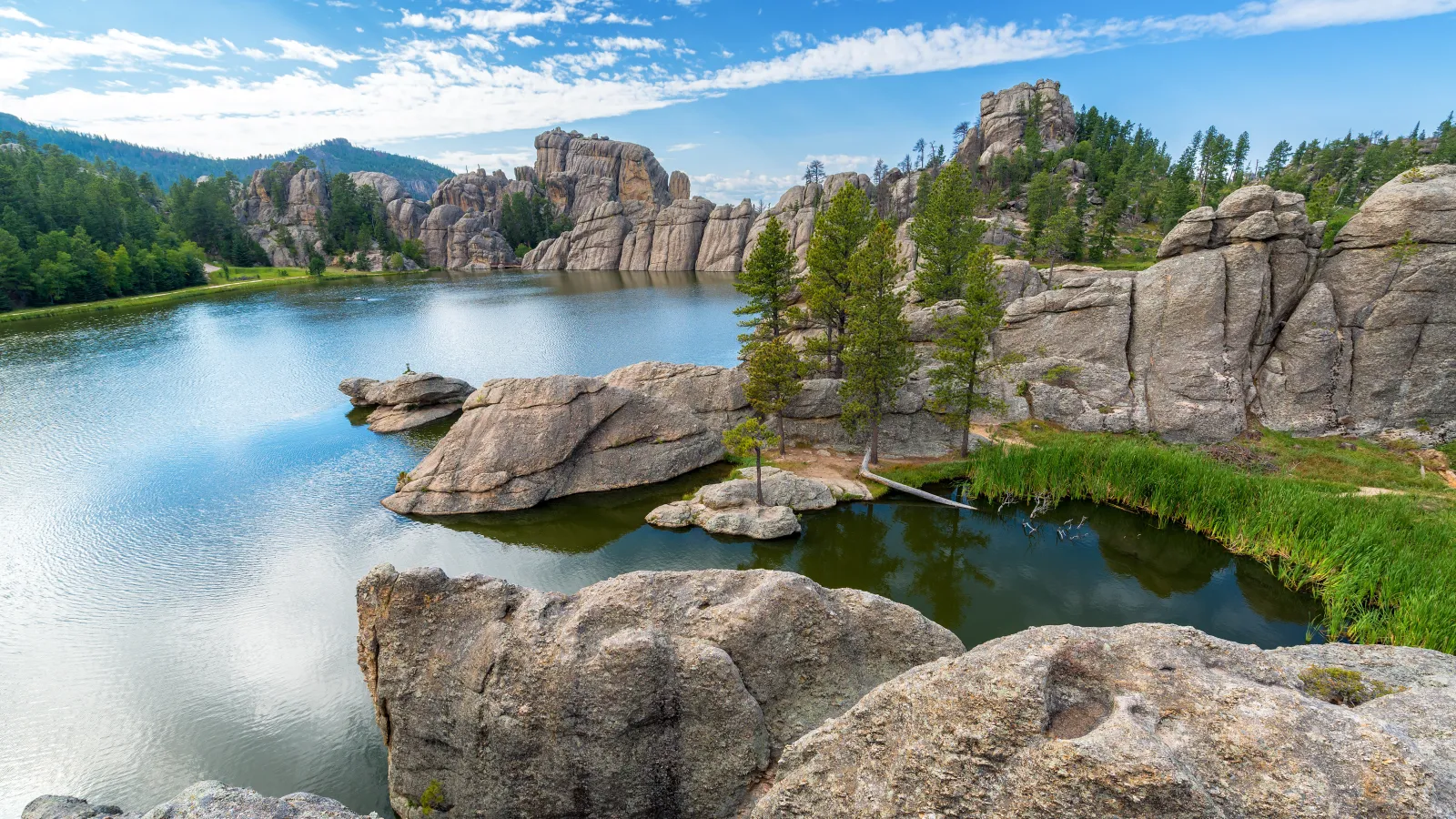 a body of water with rocks and trees around it in South Dakota