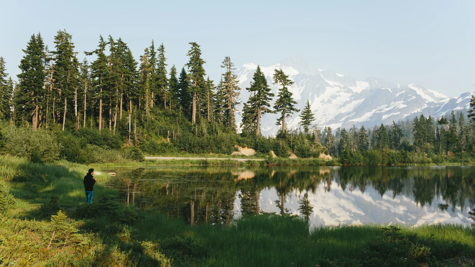 a person standing next to a lake