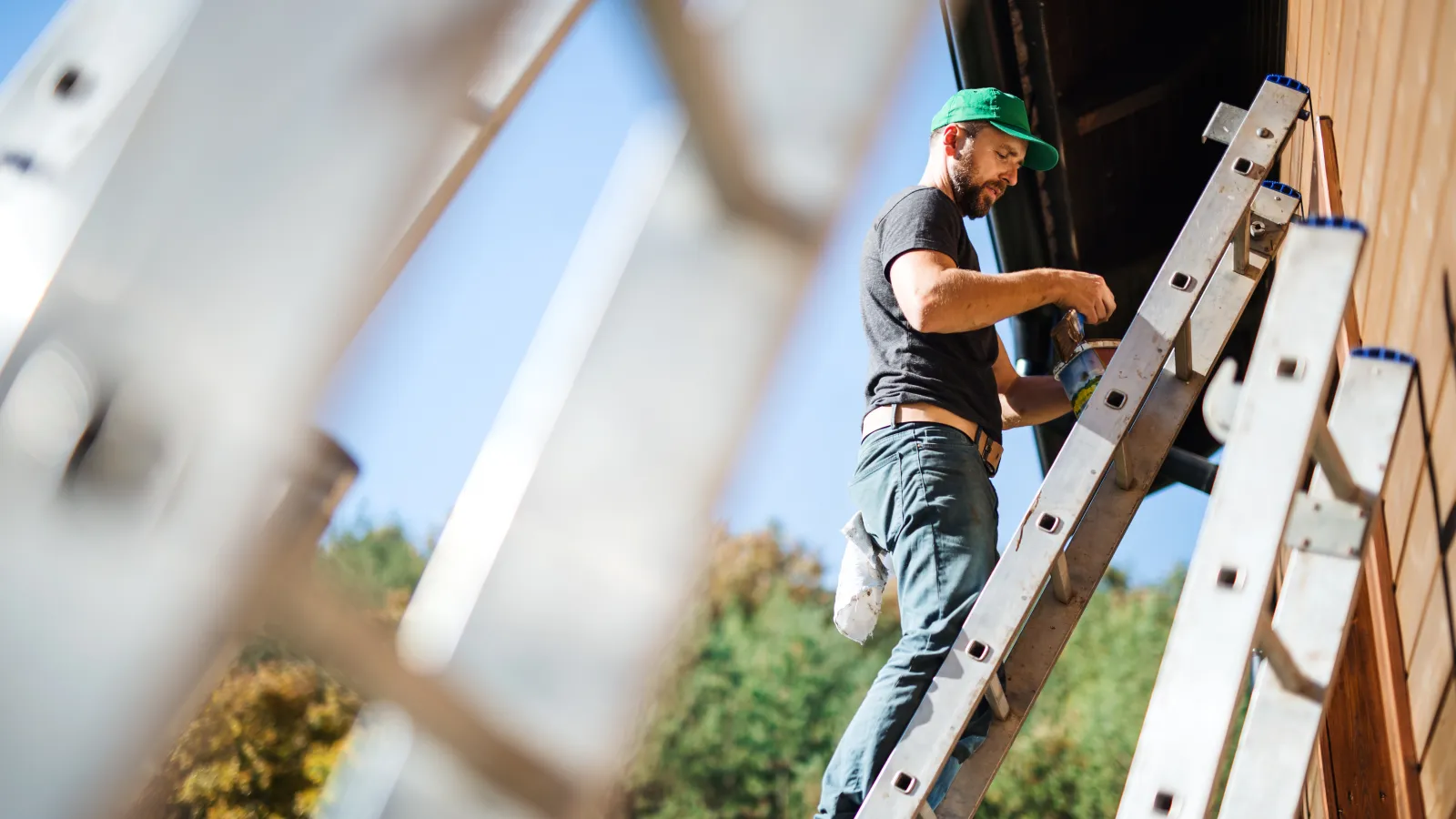 man painting home exterior