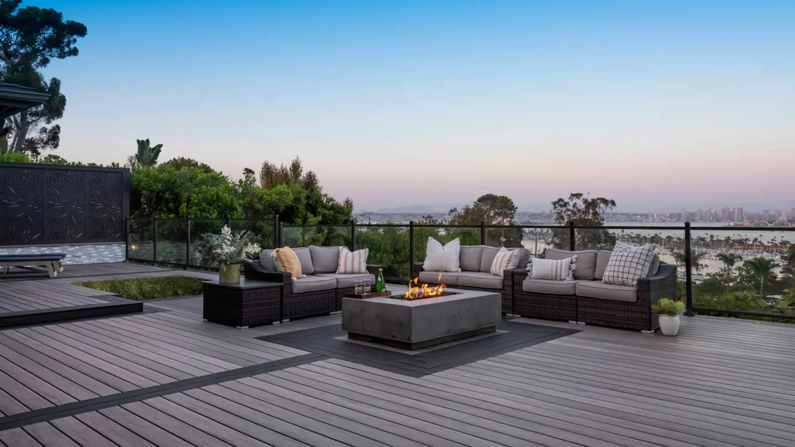 a deck with a couch and a fire pit with a view of the ocean and trees in Marietta, GA