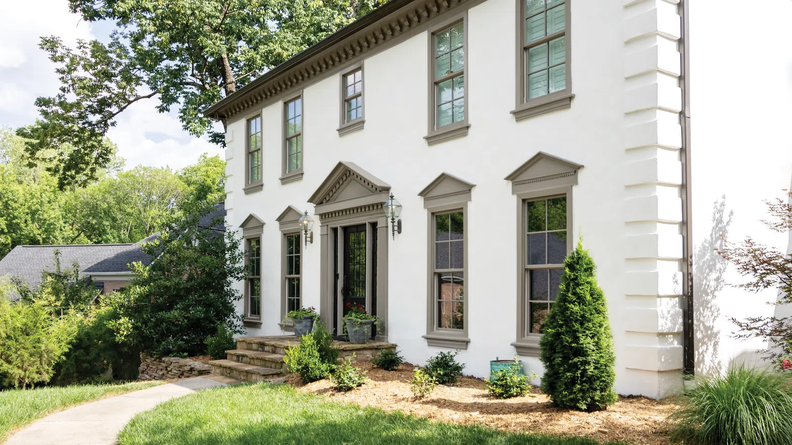 a white house with trees and bushes