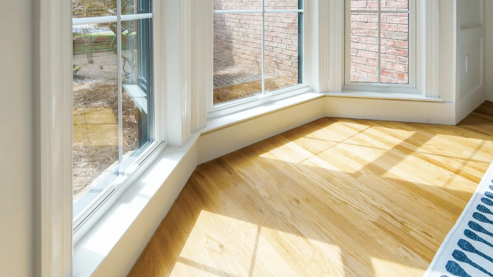 a room with a wood floor and windows