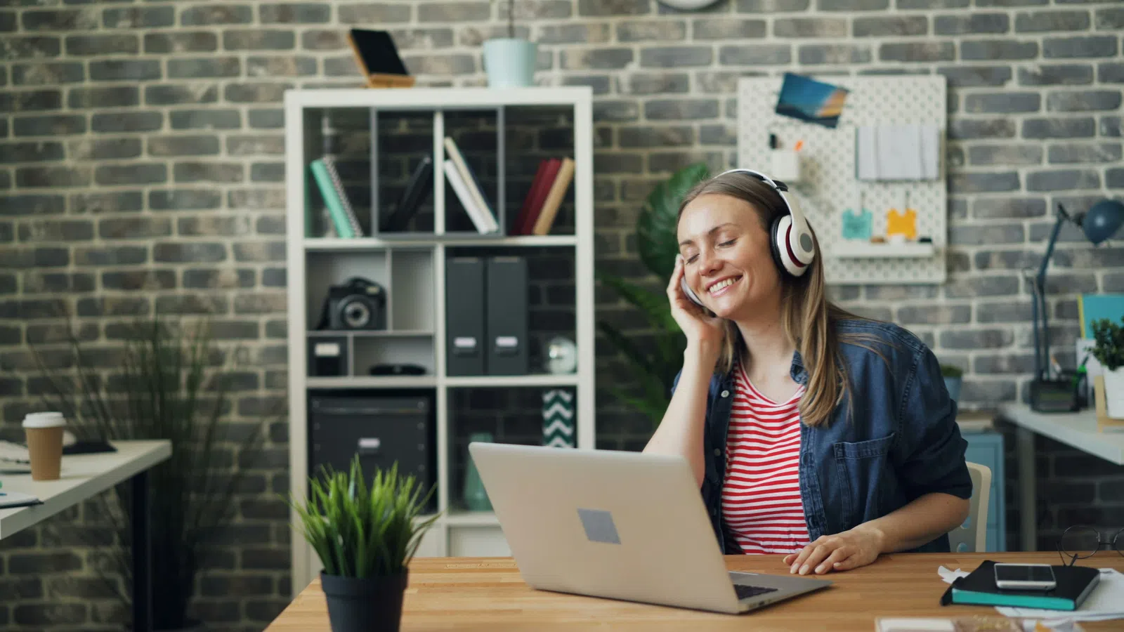 a woman wearing headphones and using a laptop
