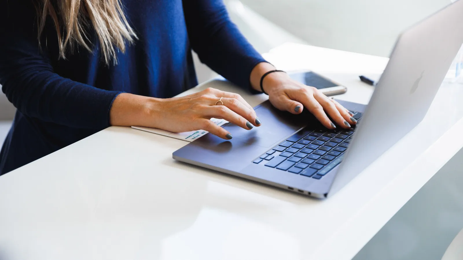 a woman sitting at a table using a laptop computer