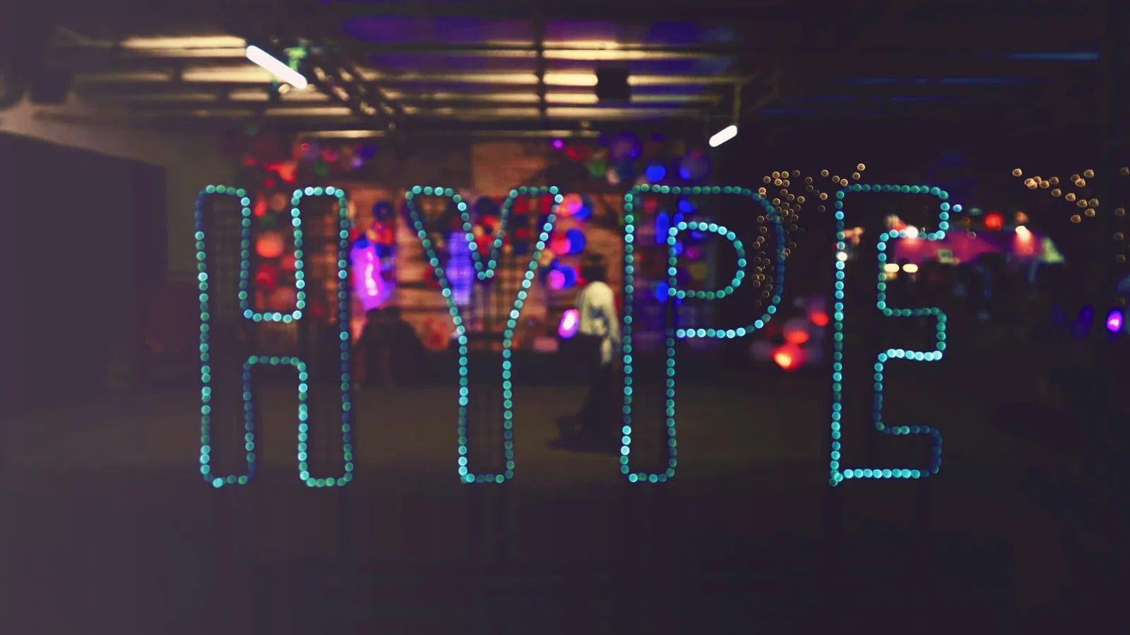a group of people standing in front of a stage with lights
