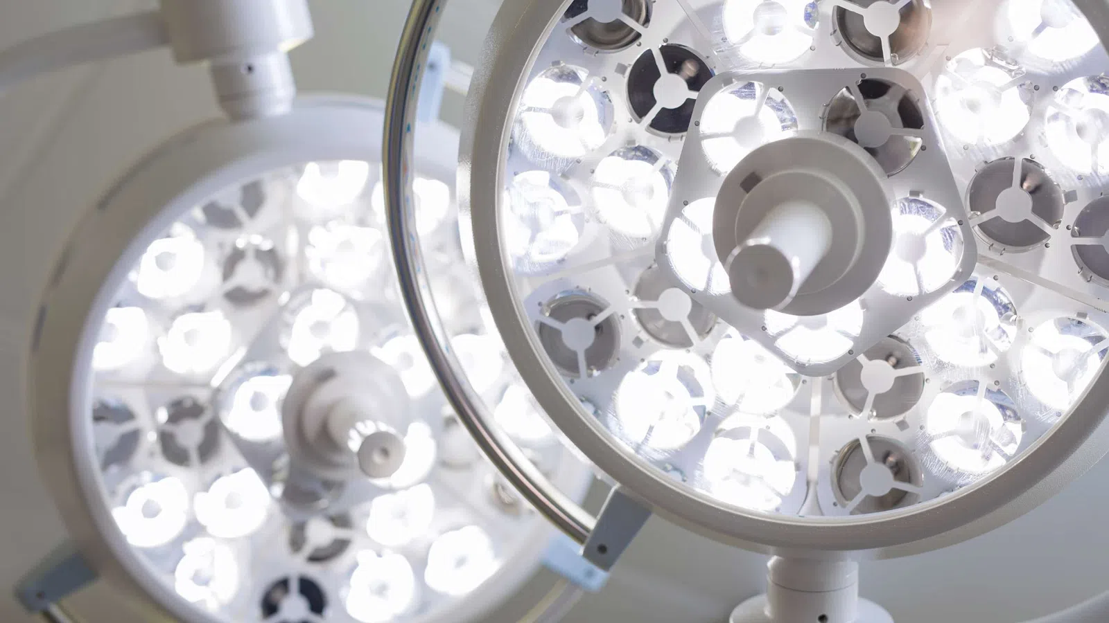 Close-up of bright LED surgical lights in an operating room, highlighting light panels and fixtures.