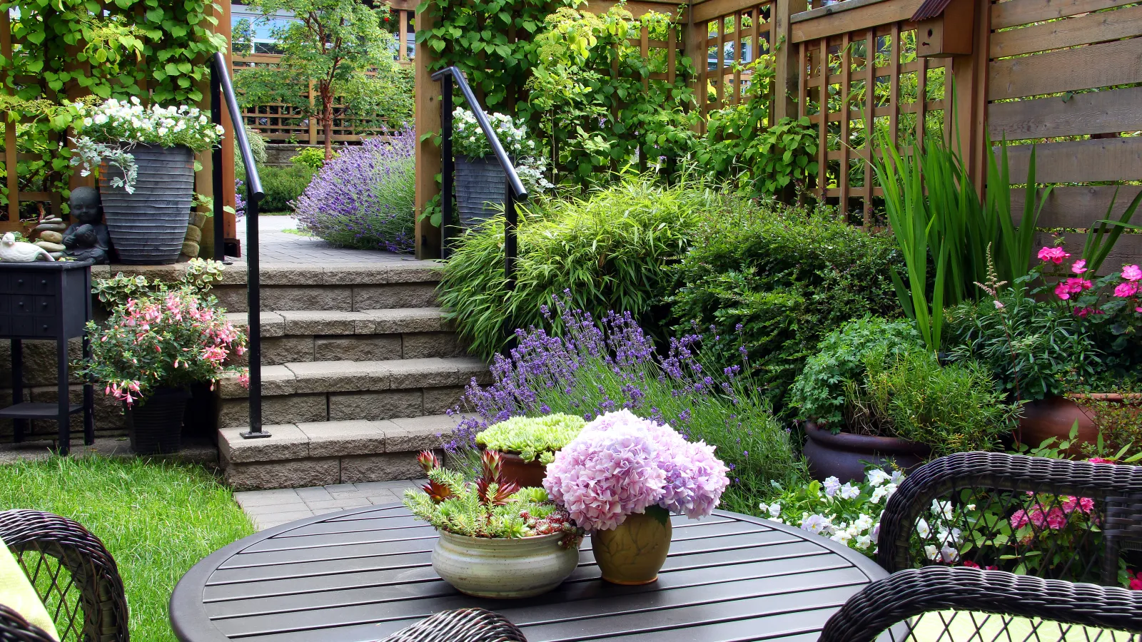 Armstrong landscape design with salvia, pots with flowers, vines, succulents and a patio set