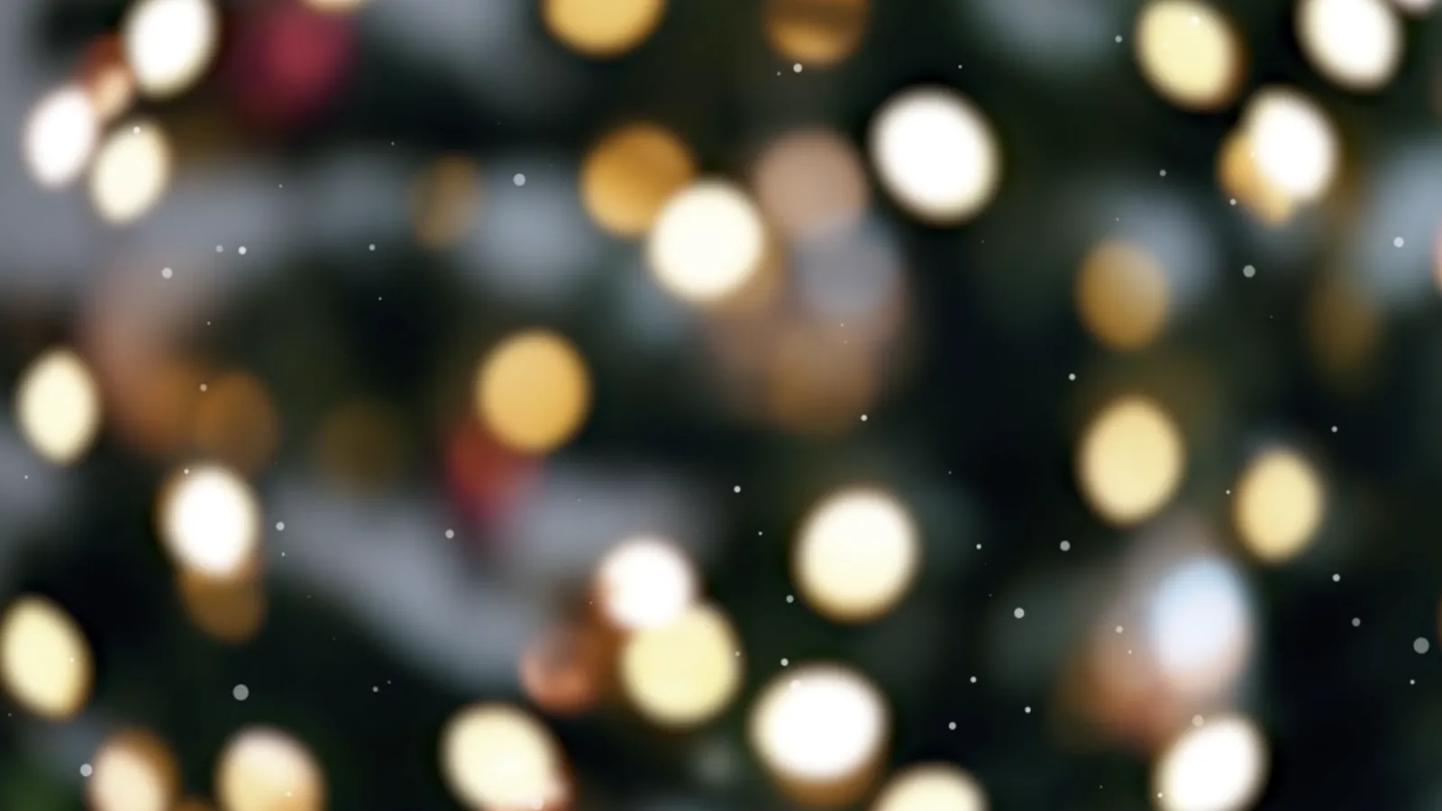 Soft glowing bokeh lights in warm white and gold tones with subtle snowflake effect on dark background