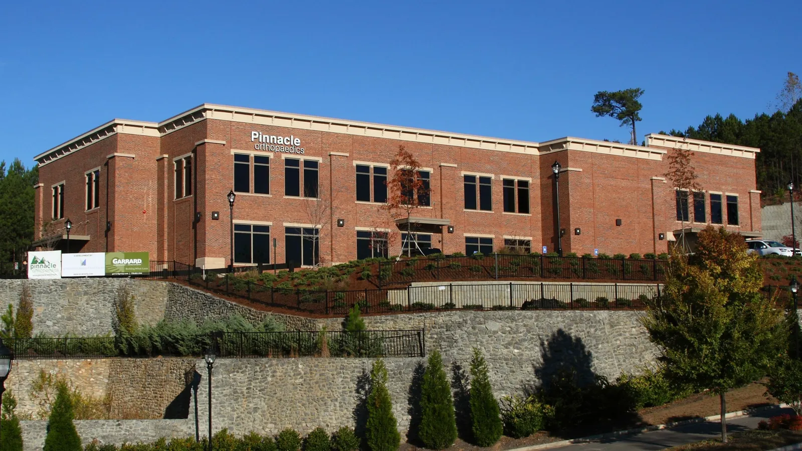 Modern brick medical office building for Pinnacle Orthopaedics with clear blue sky and landscaped surroundings.