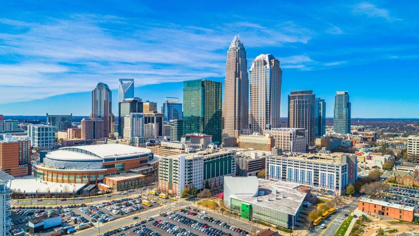 Aerial view of Charlotte city skyline with modern skyscrapers and clear blue sky during daytime.