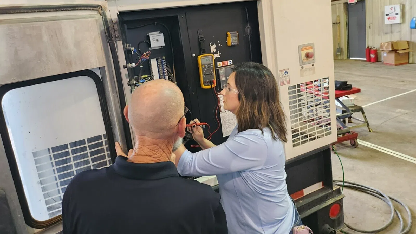 a man and woman looking at a machine