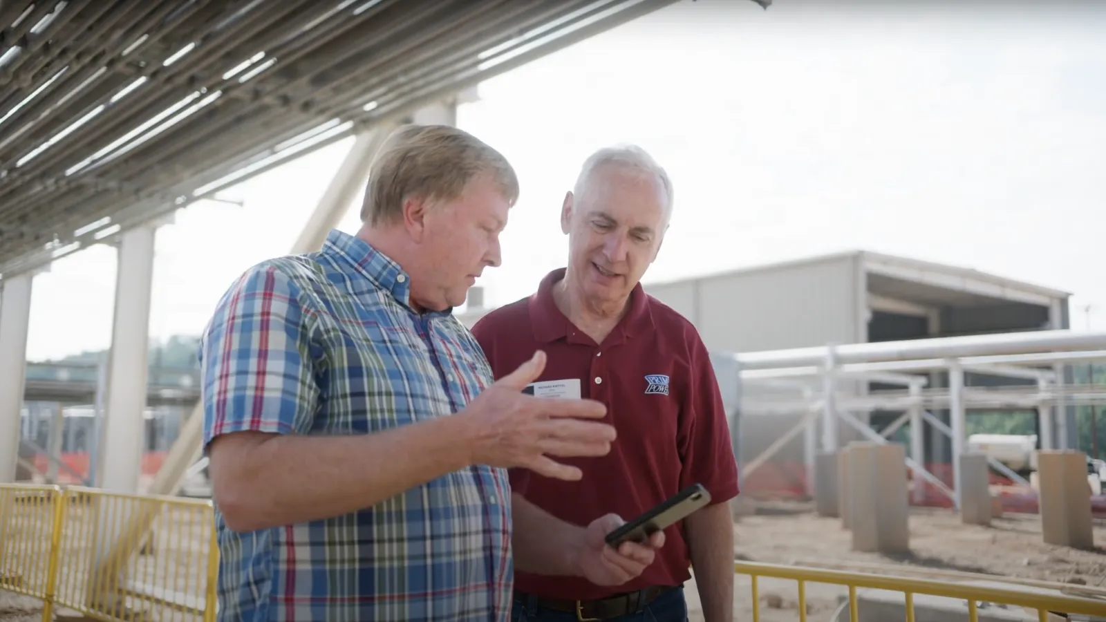 a couple of men looking at a phone