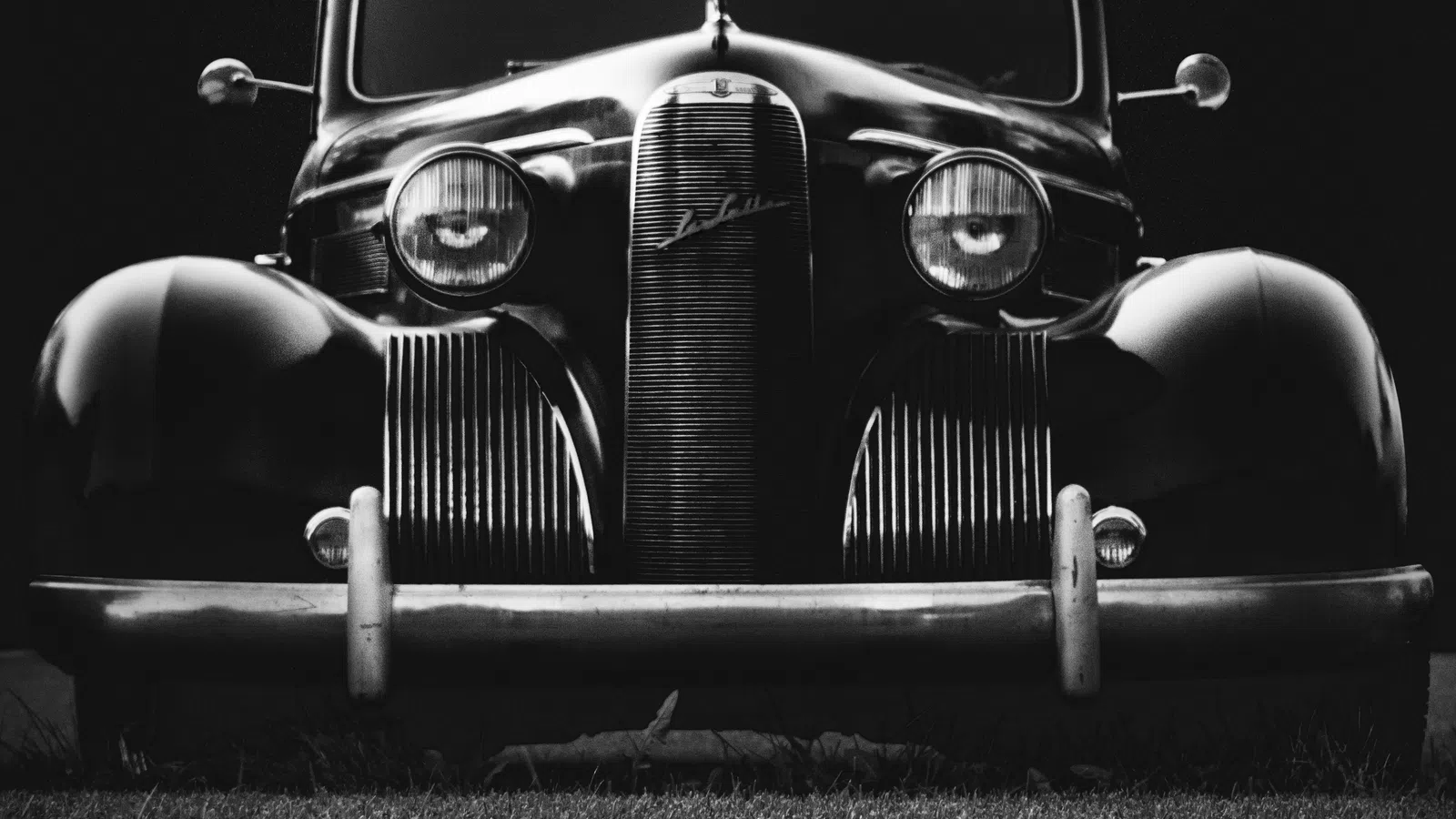 a vintage car parked on grass