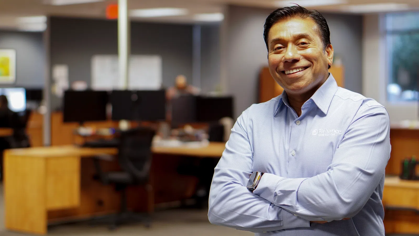 a person smiling with the arms crossed