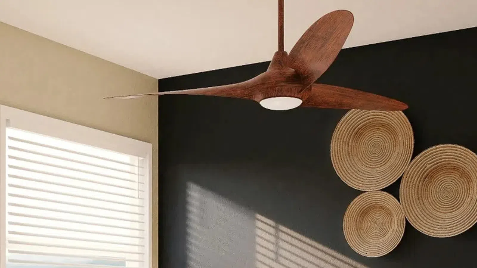 Modern living room with black accent wall, abstract art, woven wall decor, wooden ceiling fan, and window blinds.