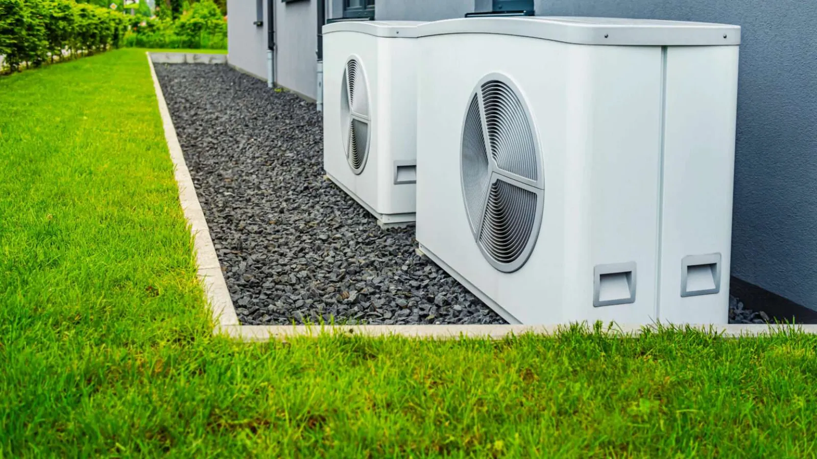 Technician with glasses inspecting and repairing an outdoor HVAC unit during daytime.