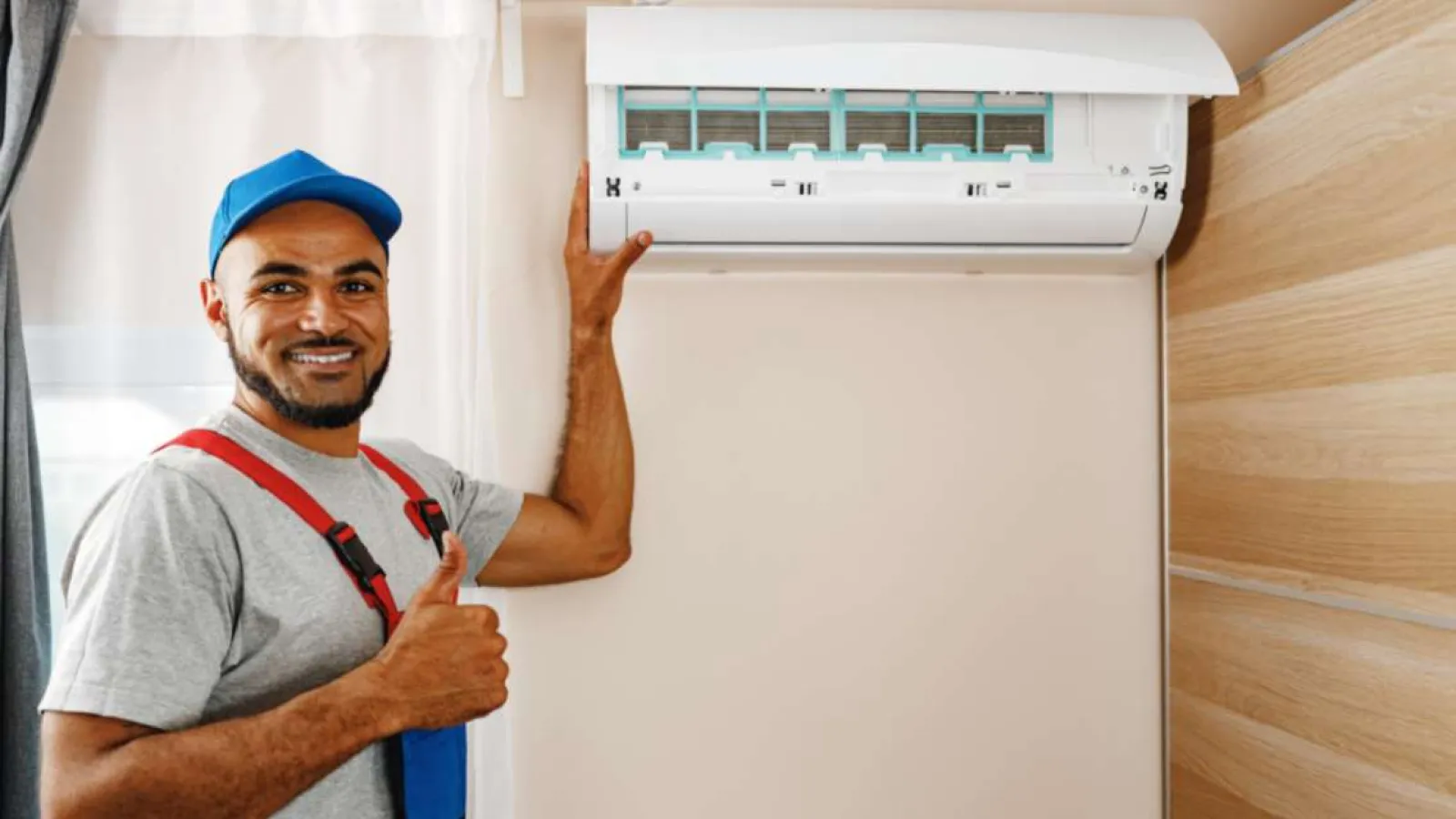 Technician with glasses inspecting and repairing an outdoor HVAC unit during daytime.