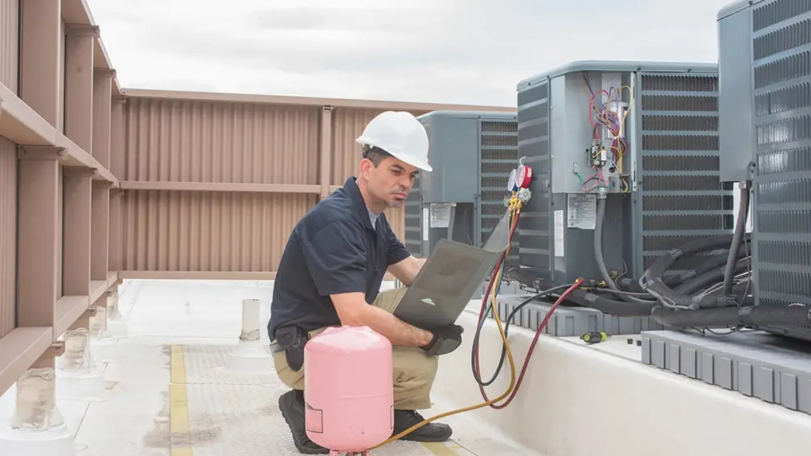 Hand pressing the power switch on a white electric heater in a cozy indoor setting.