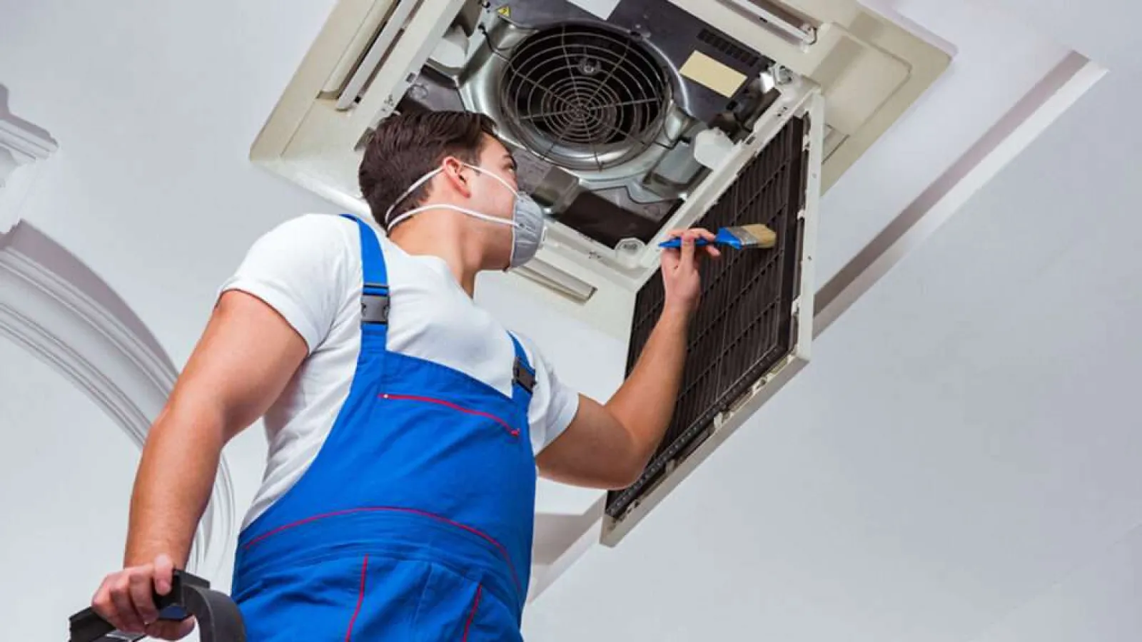 C M Heating Cooling team posing in front of branded service vans at warehouse parking lot in uniform.