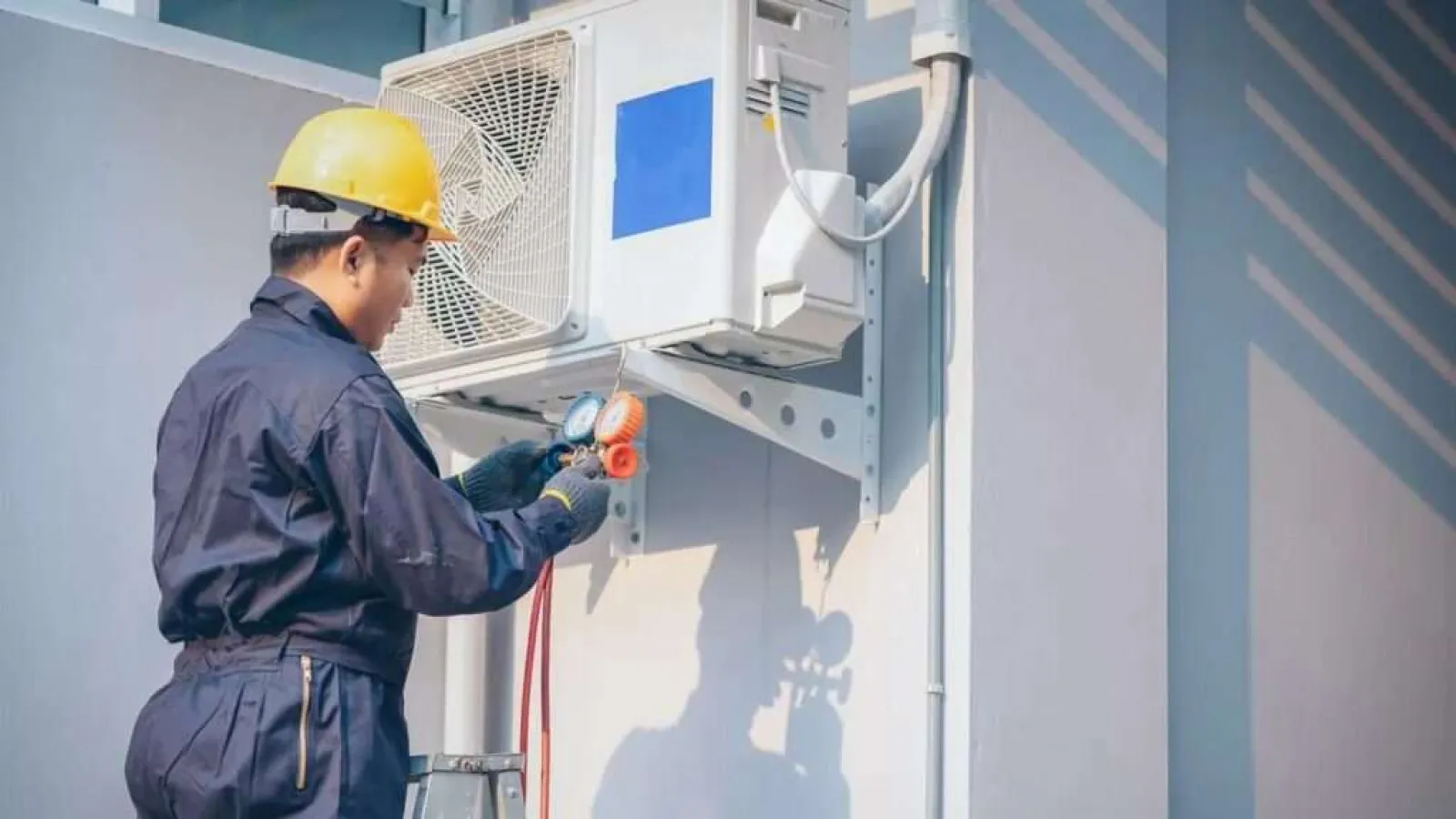 Hand pressing the power switch on a white electric heater in a cozy indoor setting.
