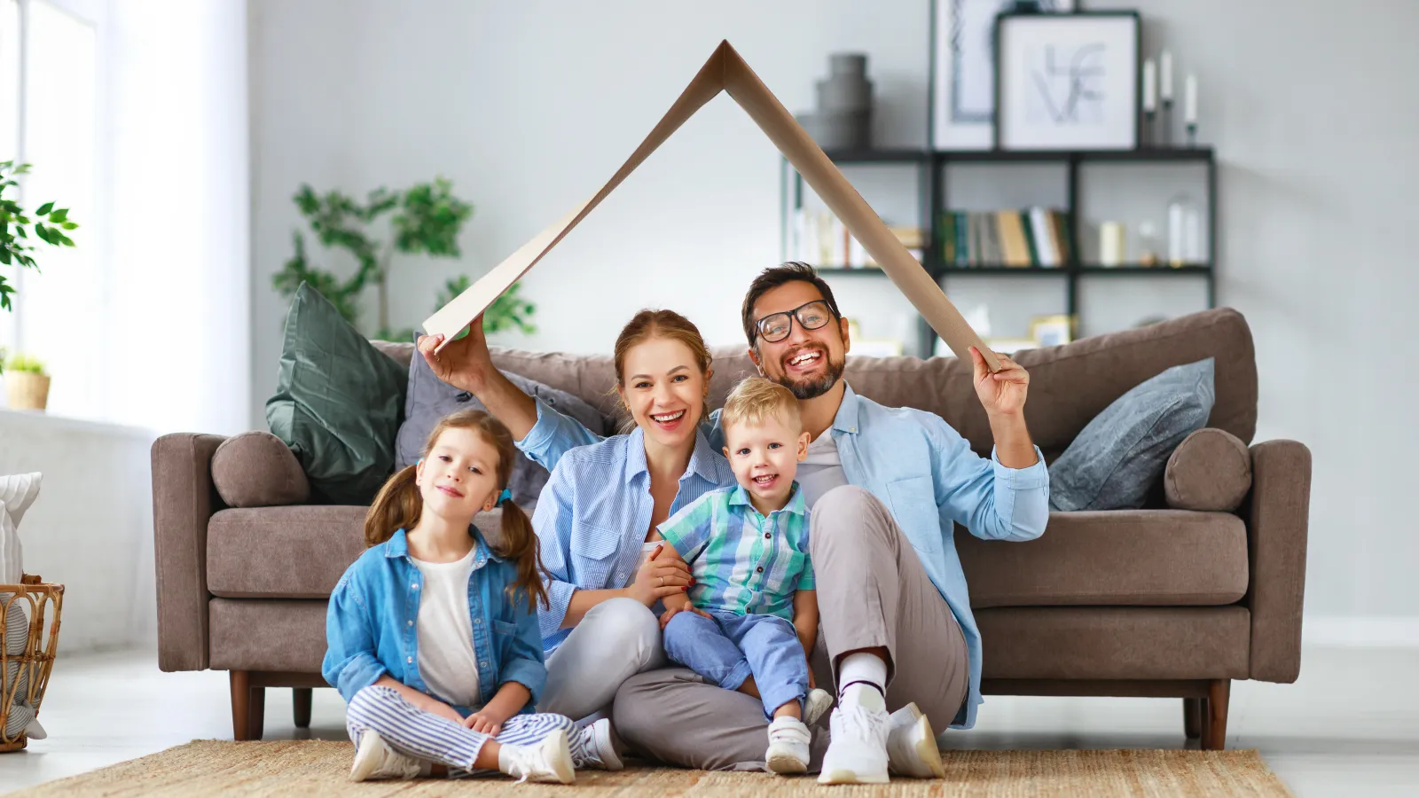 a person and two children sitting on a couch with a wooden object