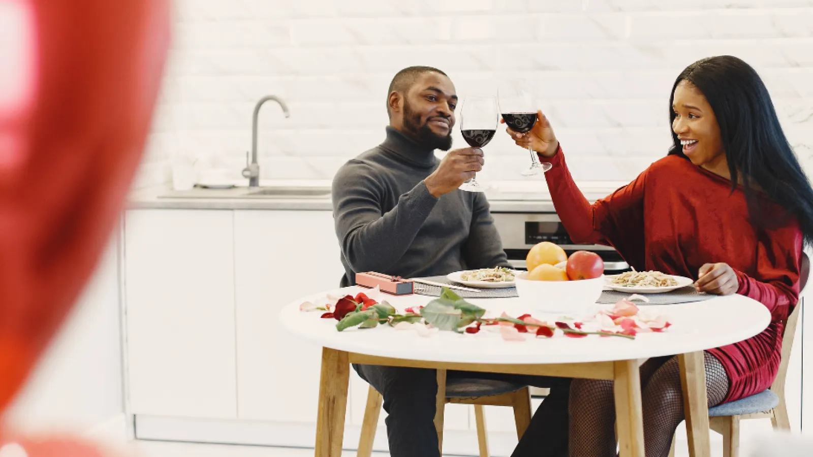 a man and woman sitting at a table with food and drinks