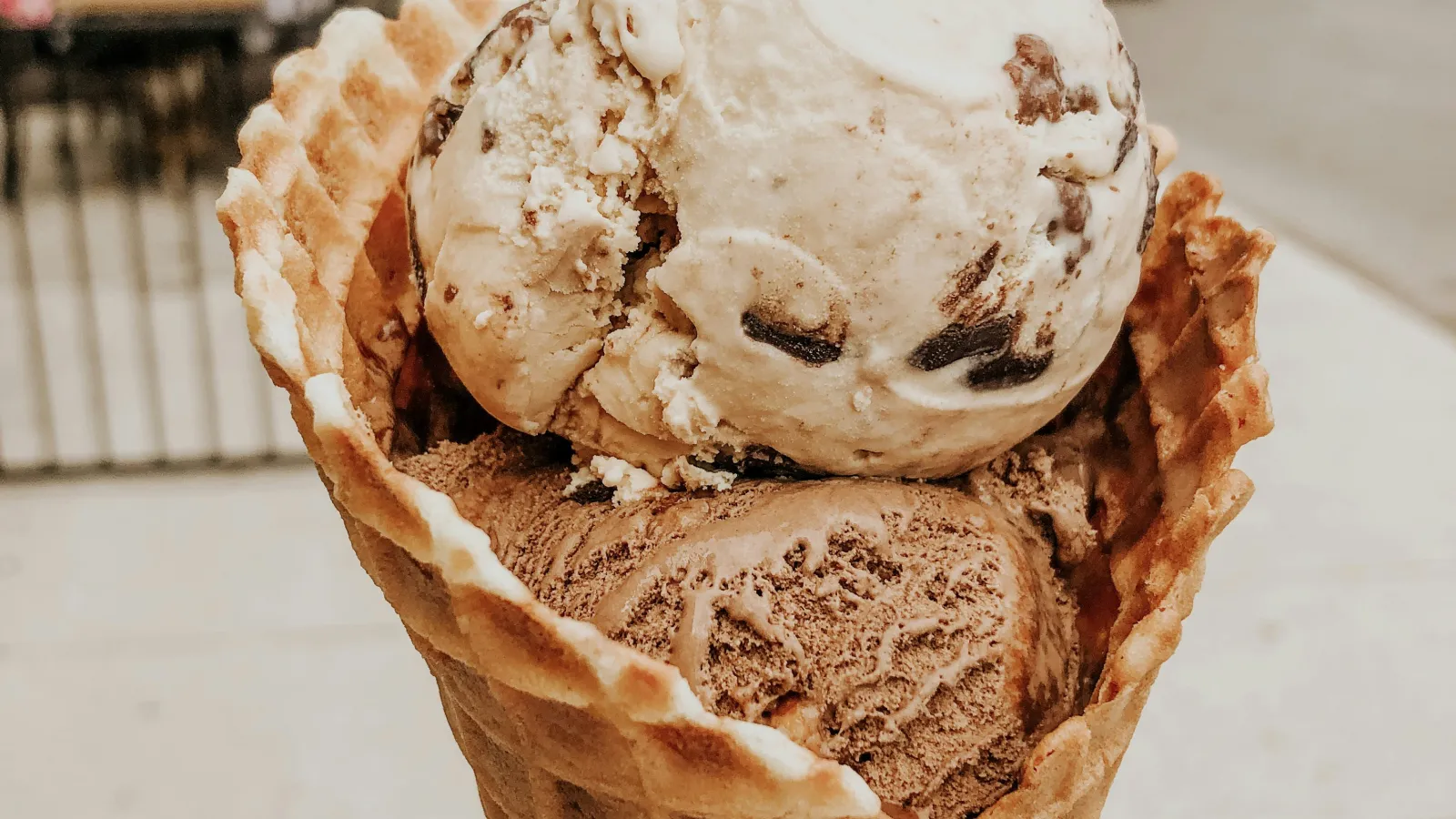 a hand holding a cone of ice cream