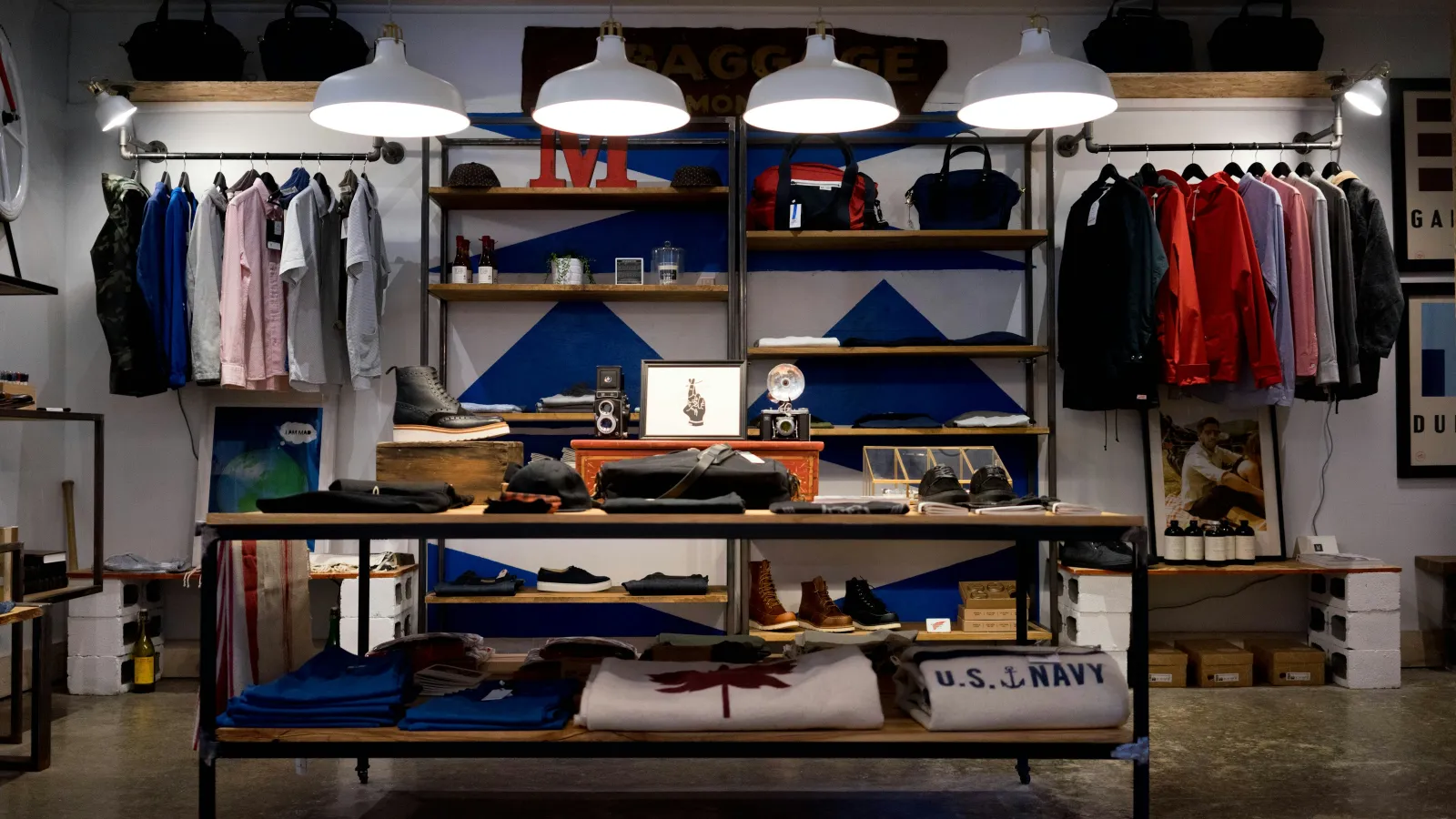a store with a shelf full of clothes and a white bed