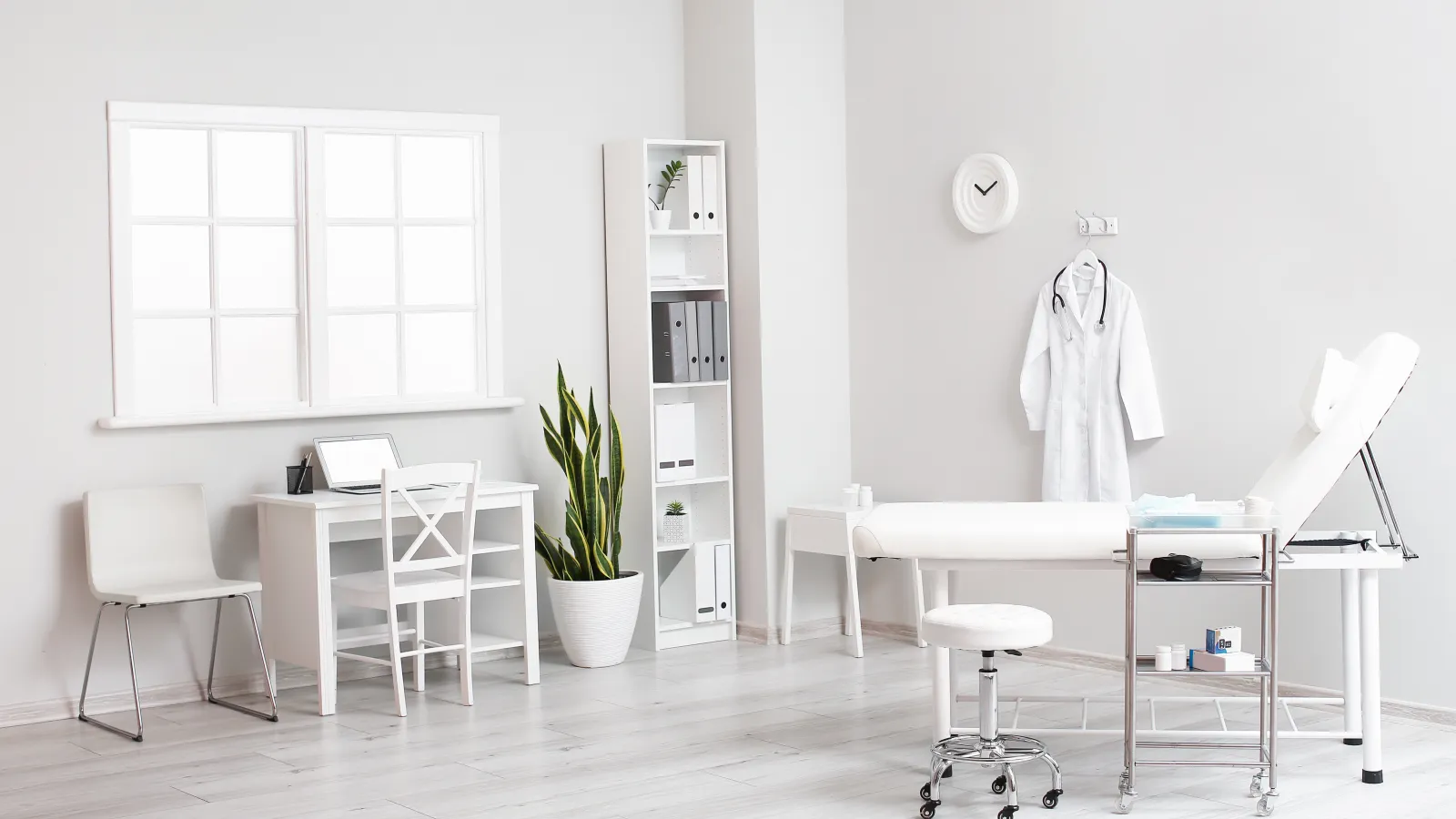 a room with a table chairs and a shelf with a laptop on it