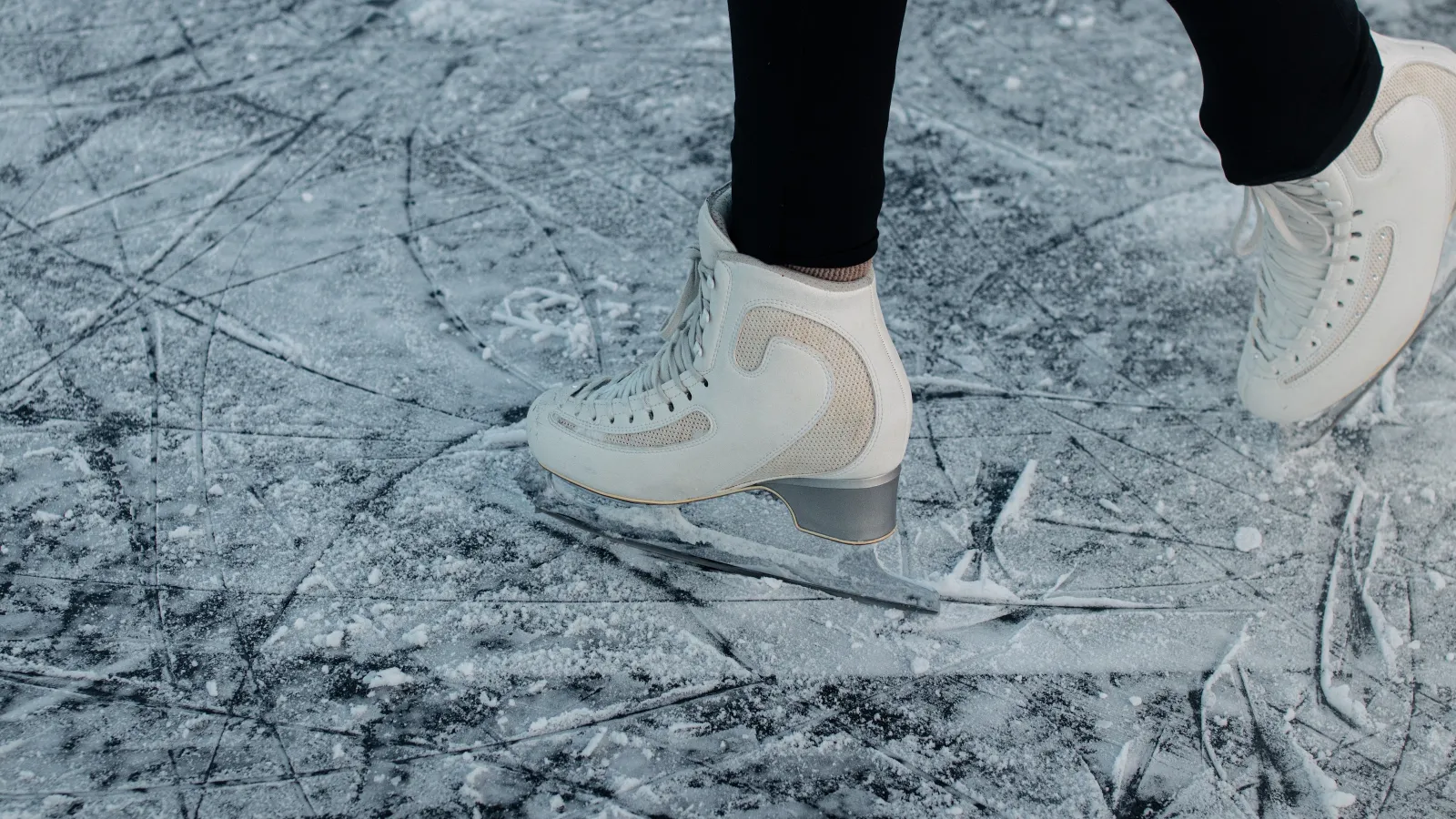 a person's feet in white shoes on a wet road