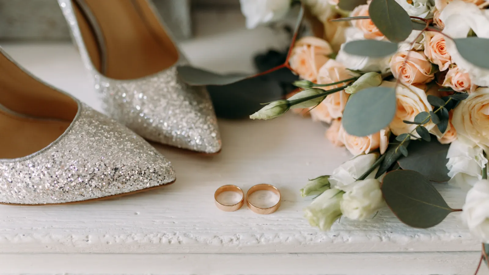 a pair of shoes next to a plant with flowers