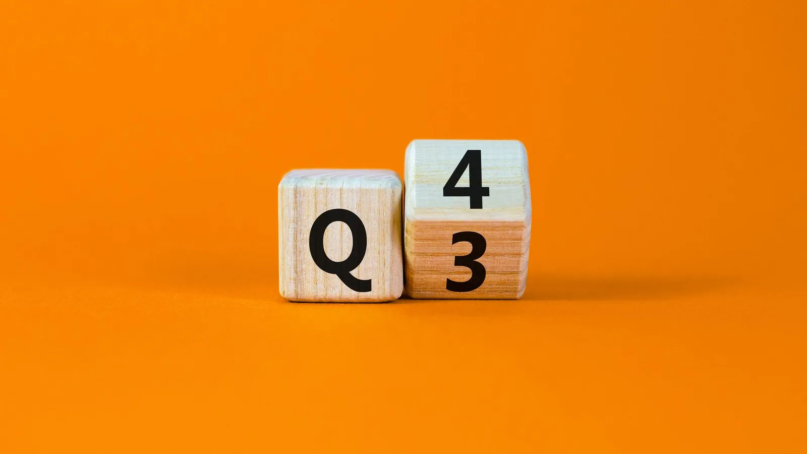 Wooden blocks on an orange background displaying Q4 and numbers 3 and 4, symbolizing quarter four.