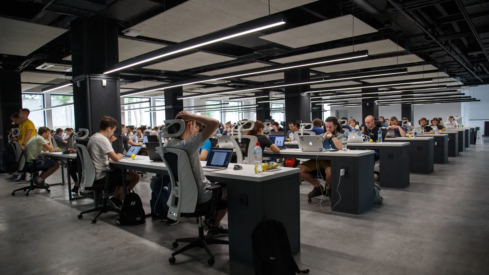 a group of workers sitting at desks in a large room