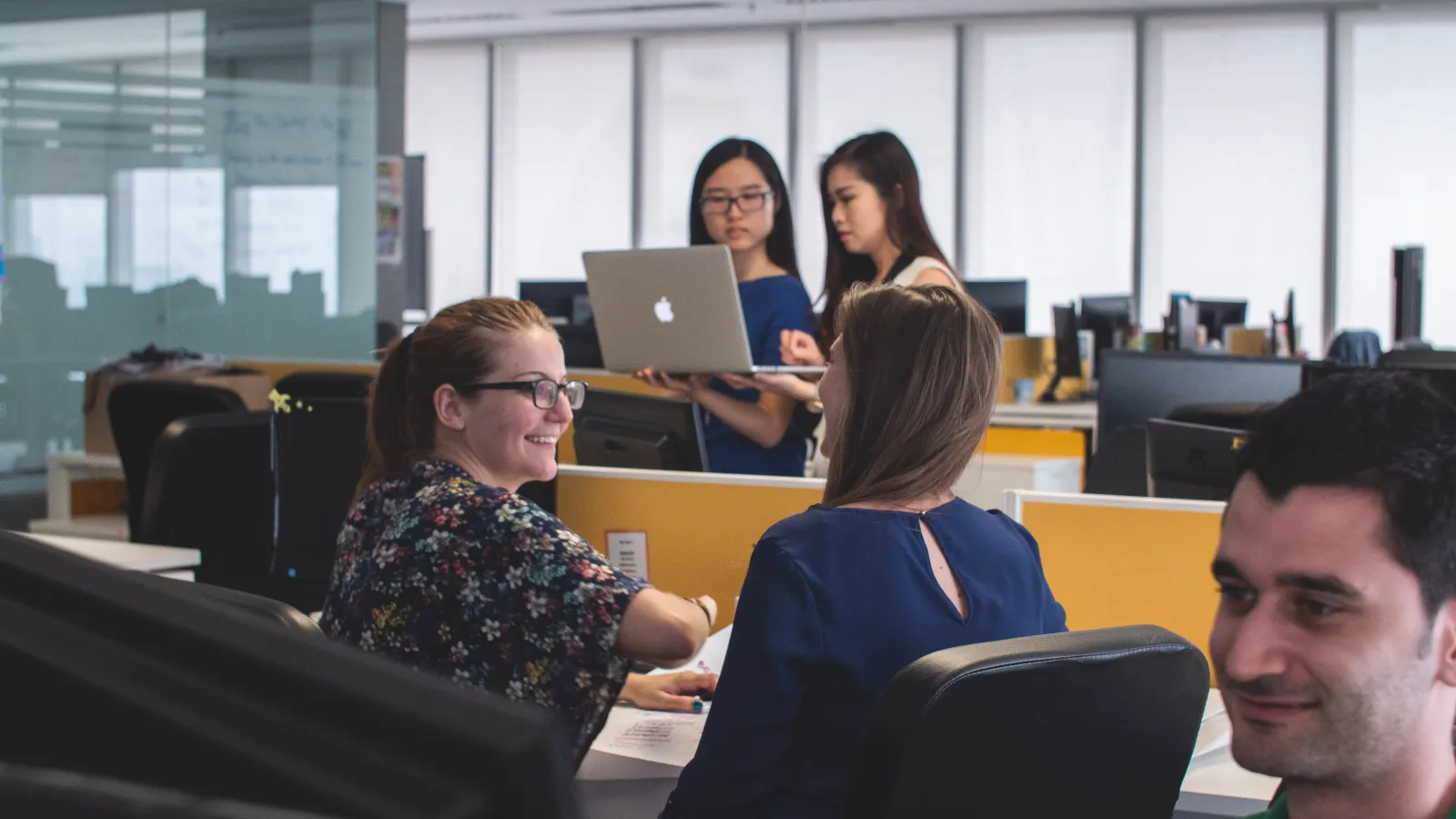 a group of people sitting at desks in a room