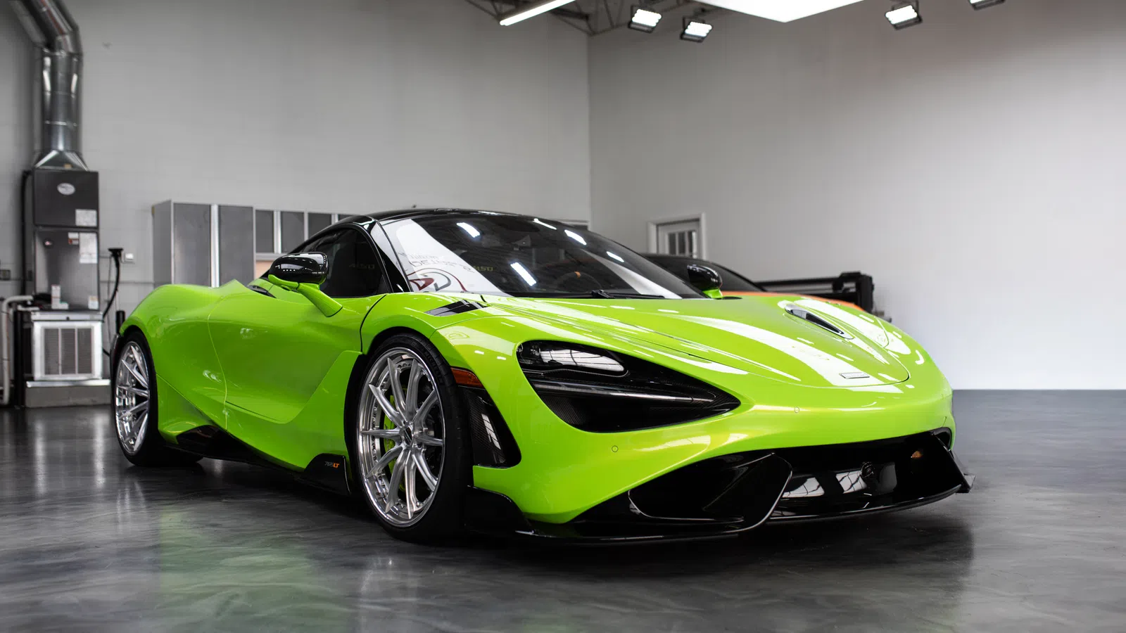 Bright green luxury sports car with aerodynamic design parked in a modern showroom with polished floors.