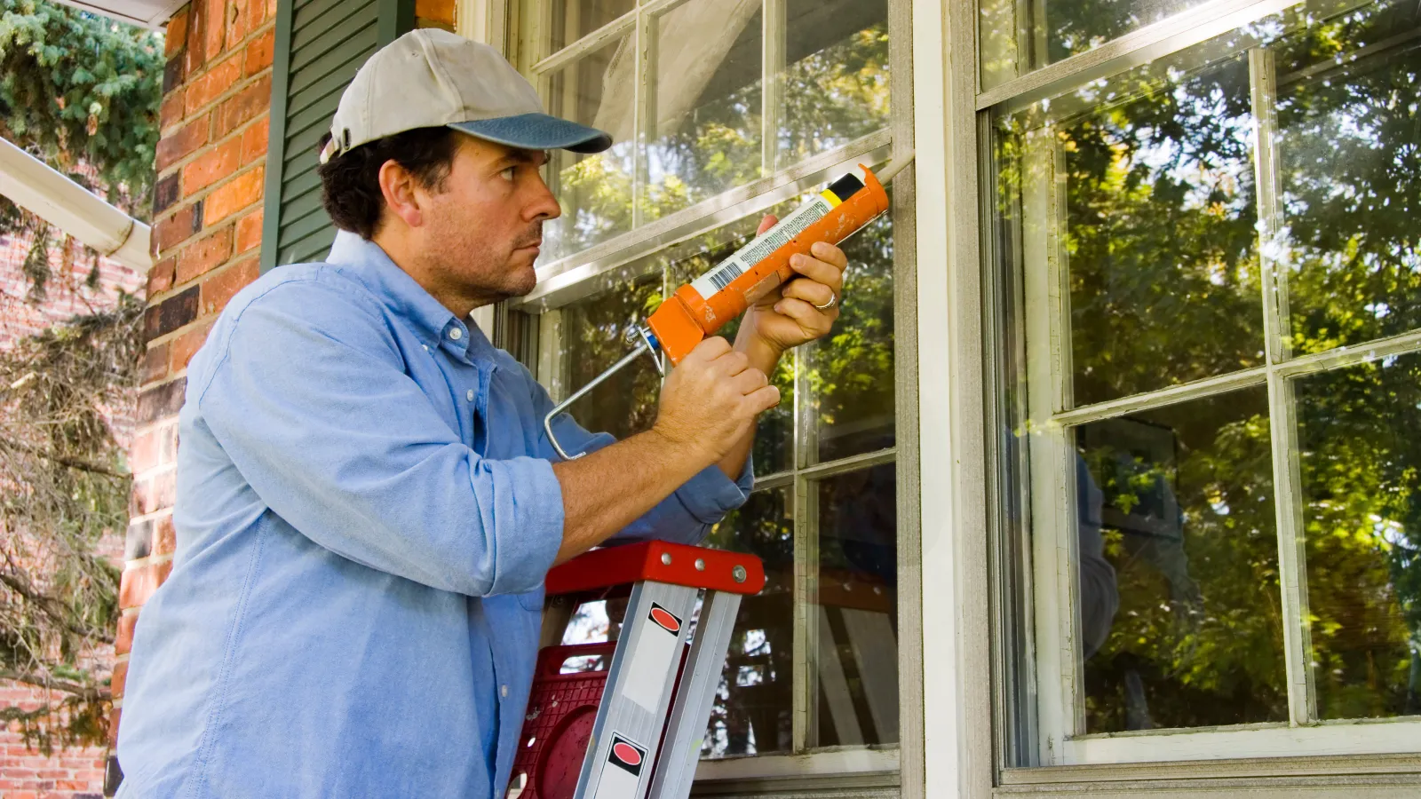 a man holding a red and white object in front of a window