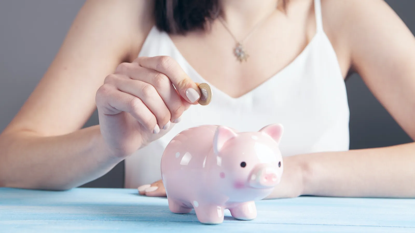 a woman using a pink piggy bank