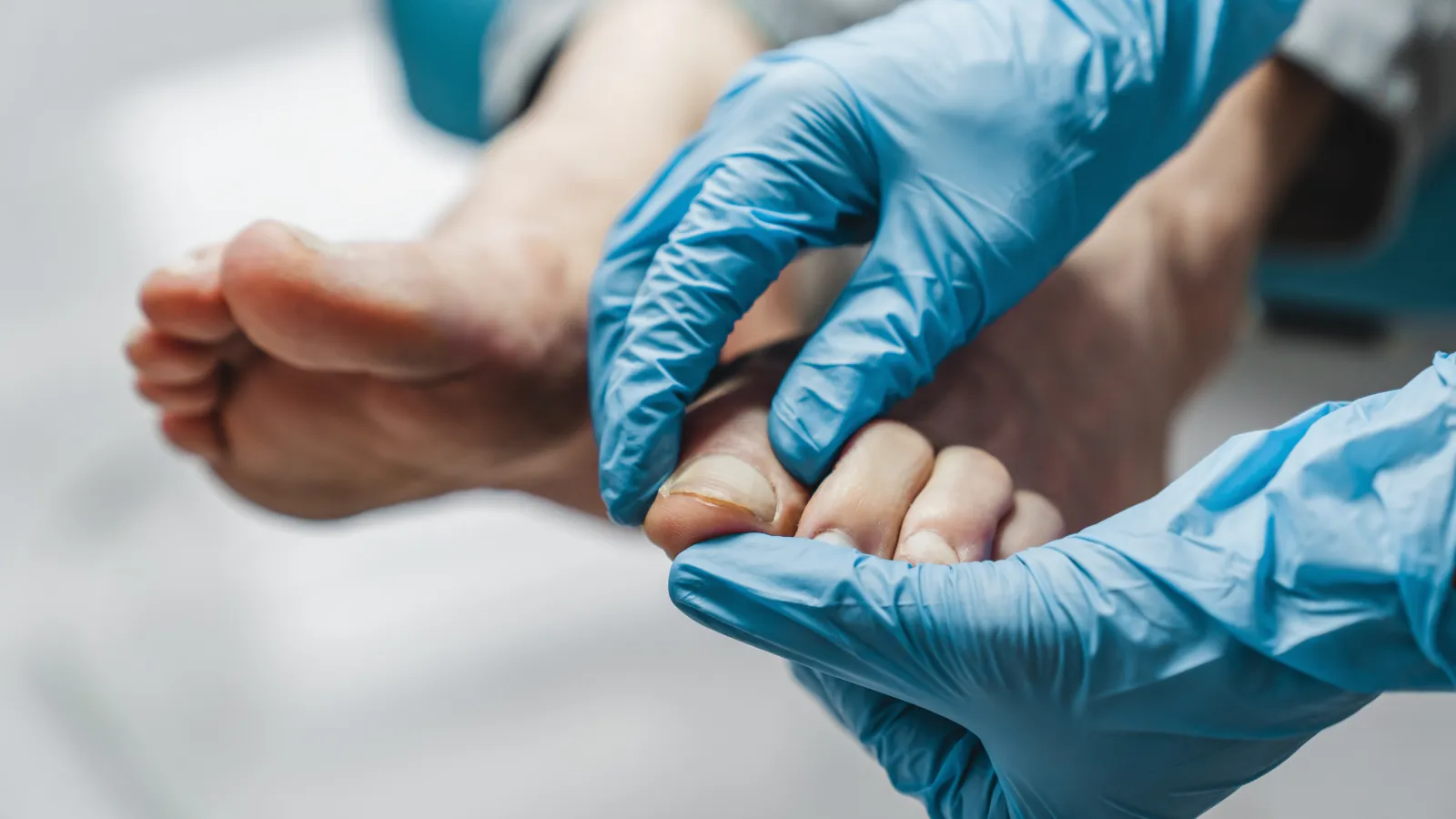 medical gloved hands touching feet