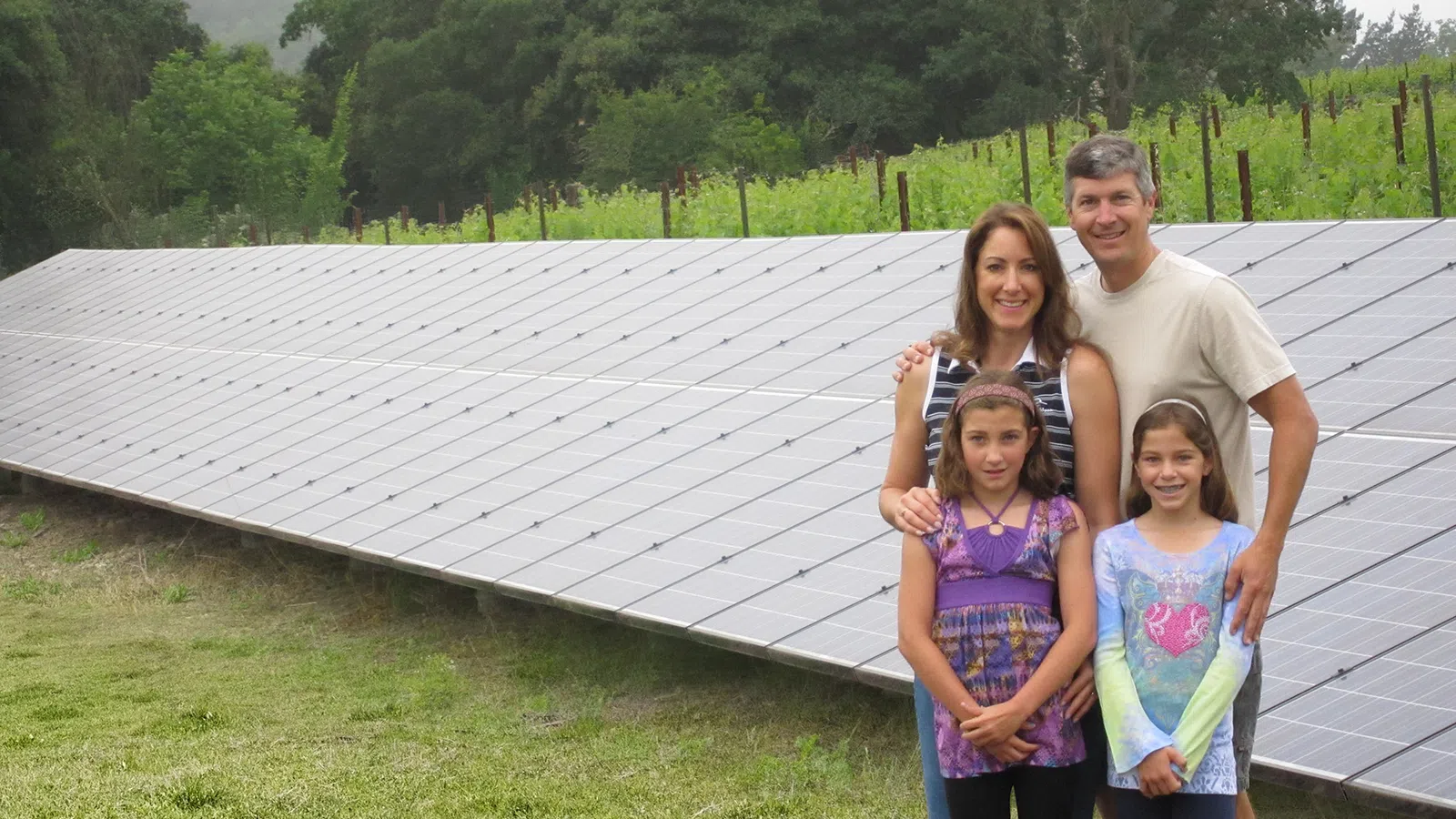 a family posing for a photo in front of a solar panels at their napa home