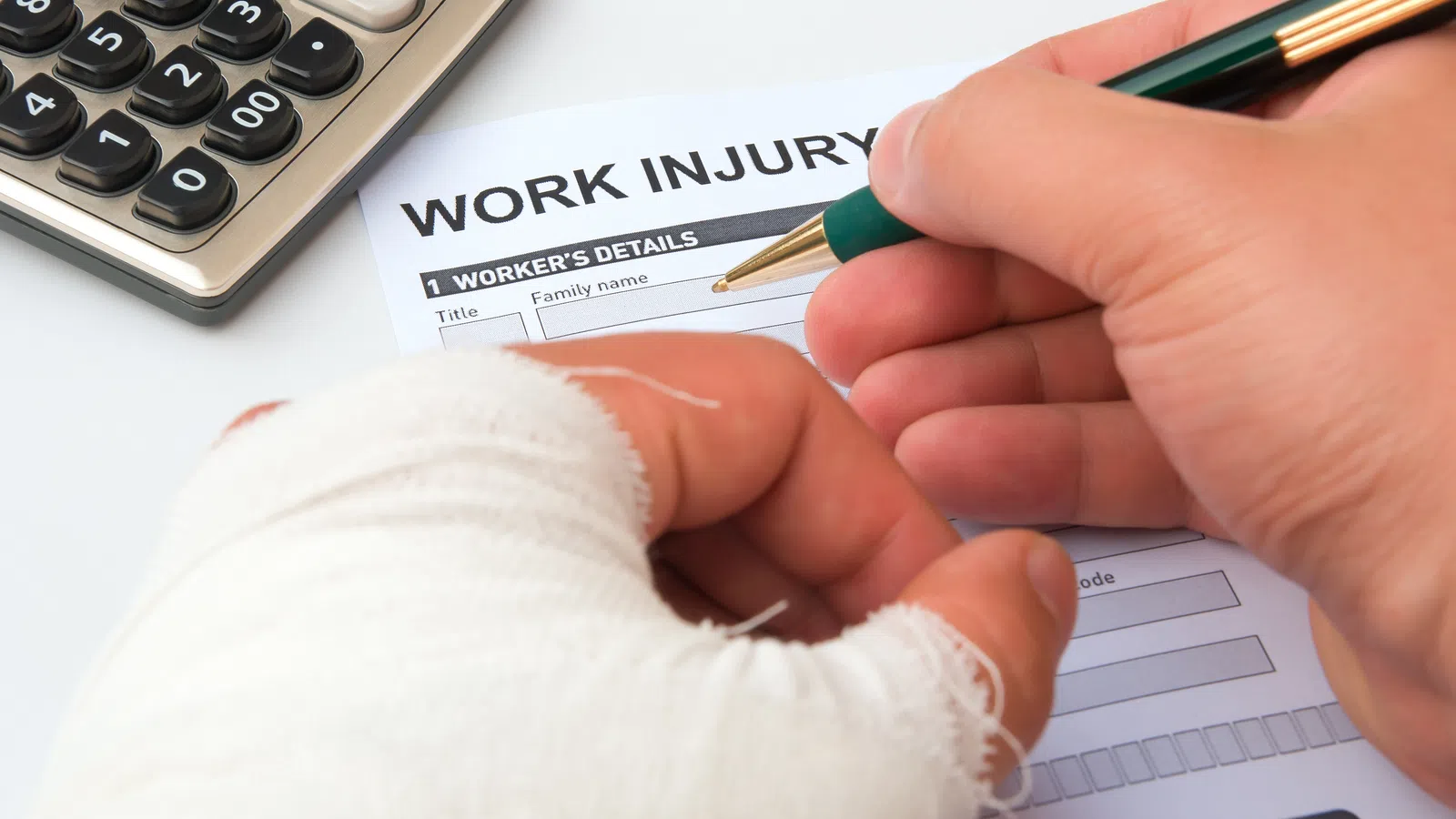 Work injury claim form on wooden desk with judge gavel and eyeglasses nearby, symbolizing legal proceedings.