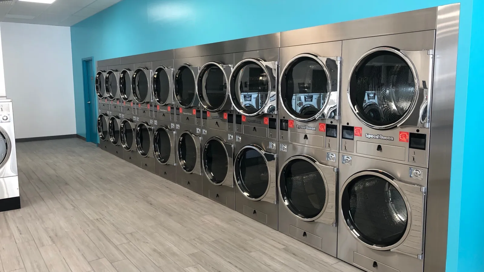 a room with a row of washing machines