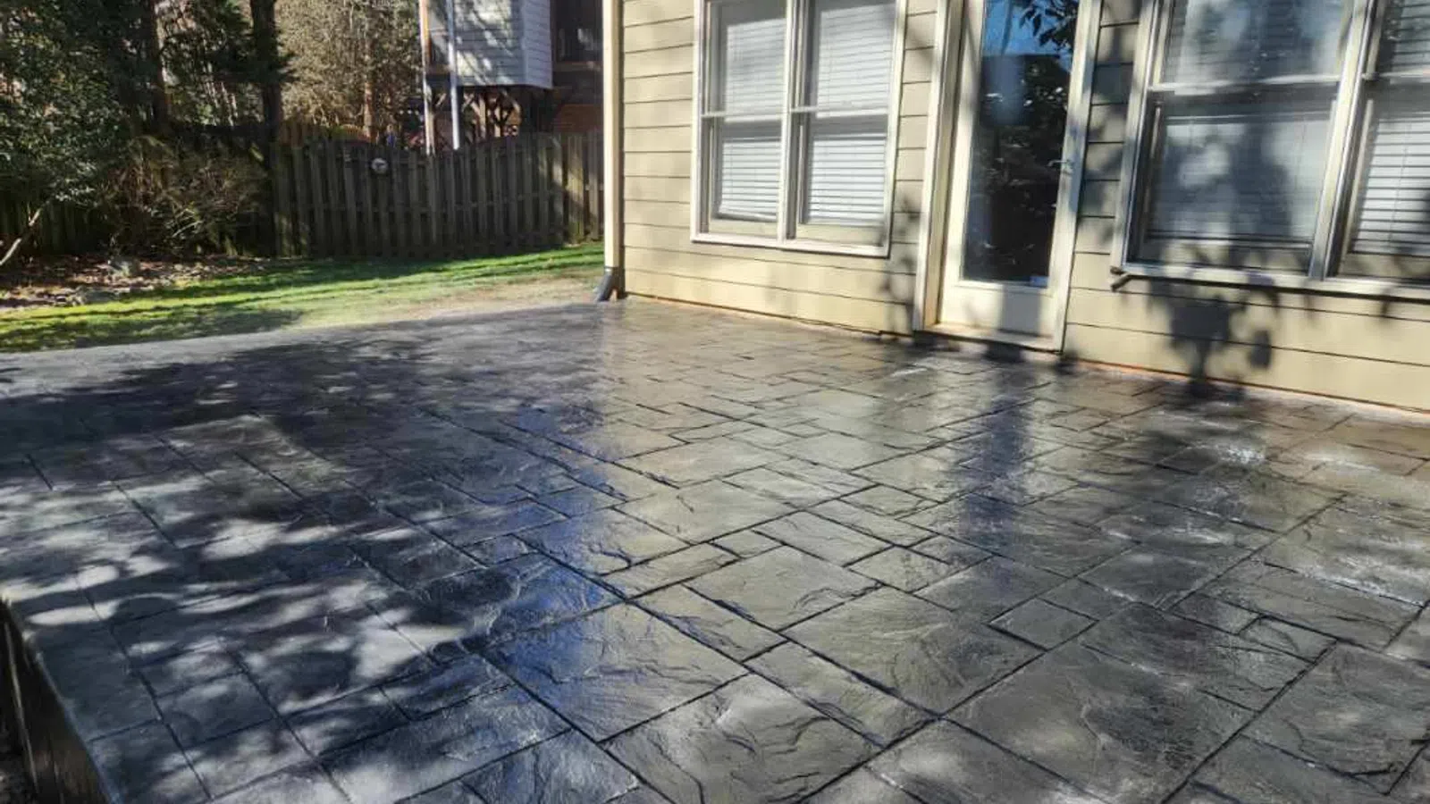 a stone paved area with a building and trees