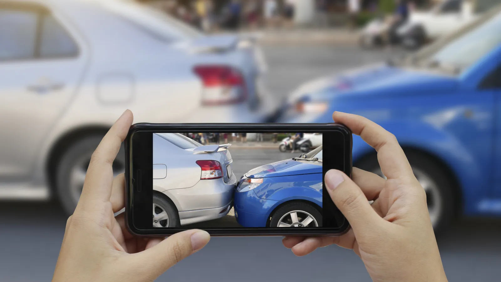a person taking a picture of a car collision