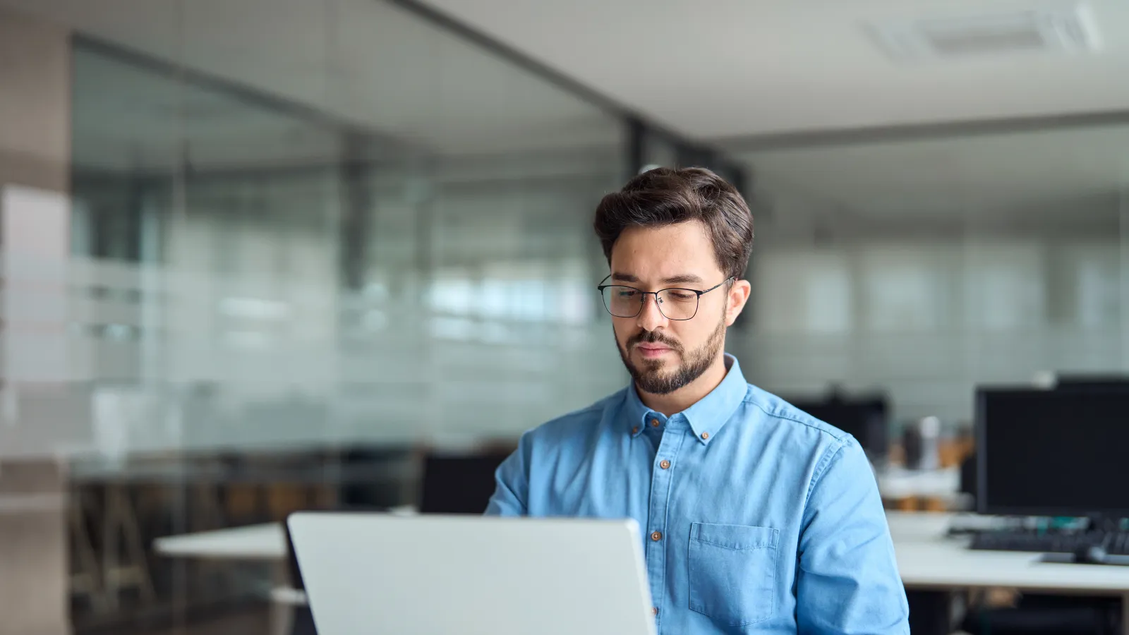 a man sitting at a desk with a laptop