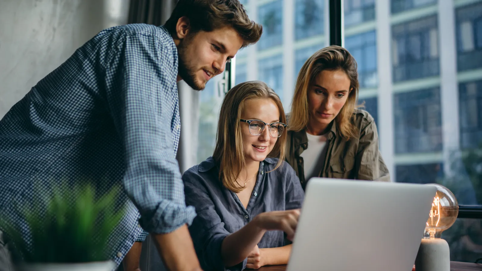 a group of people looking at a laptop