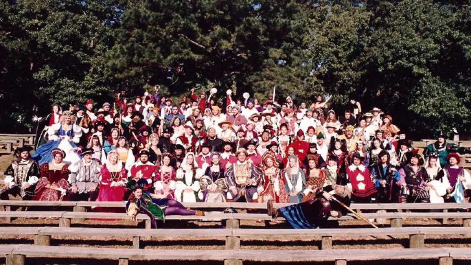 a group of people sitting on a bench in front of a crowd